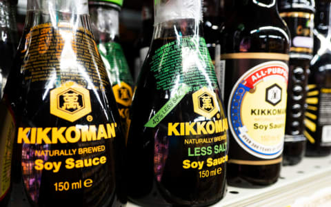 Bottles of soy sauce on a grocery store shelf.