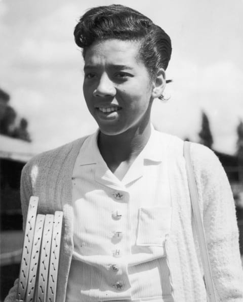 A young Althea Gibson with tennis racquets