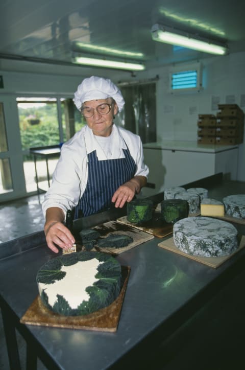 A woman wrapping yarg cheese in nettles.