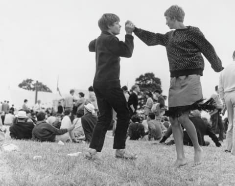 Two hipsters (also known as hepcats) dancing in a public park during an event, circa 1965. 