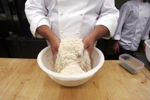 Italian chef making a dish with flour.