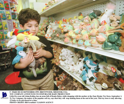 Boy in toy store with armful of Beanie Babies, circa 1999.