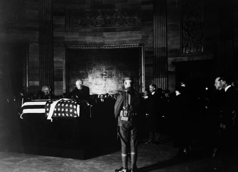 President Harding placing a wreath of flowers on the casket of the Unknown Soldier in the rotunda of the Capitol, November 9, 1921.