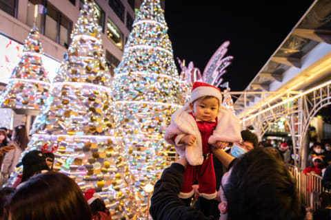 A father holds his baby son up at a shopping mall in Hong Kong.