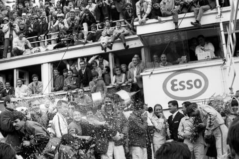 Dan Gurney and A.J. Foyt spraying people champagne in 1967.