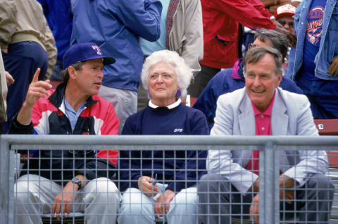 George W. Bush (left) with his parents at a baseball game.