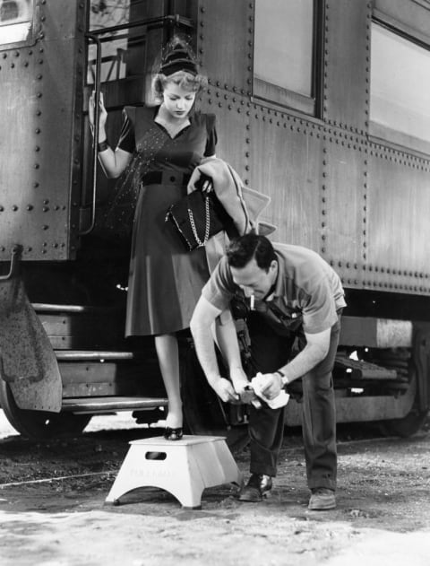 A prop man cleans Turner’s shoes between takes during the filming of ‘These Glamour Girls.’ 