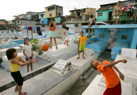 Children play ball among the graves in Manila North Cemetery.