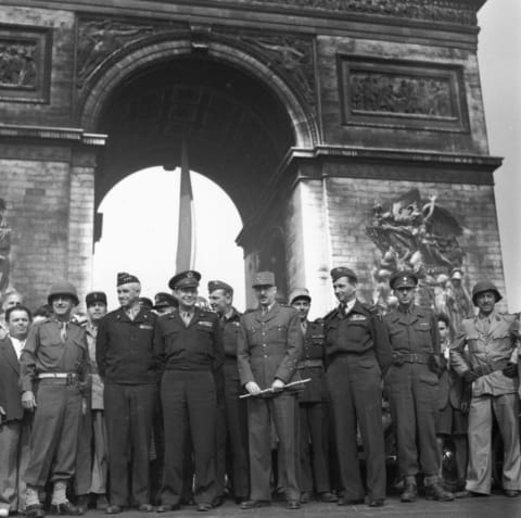 Allied leaders stand under Paris’s Arc de Triomphe after fighting their way from the beaches of Normandy to liberate France from Nazi occupation.