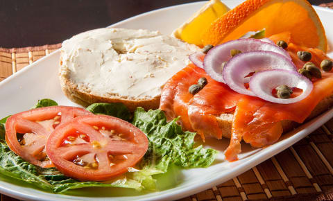 Bagel with lox, cream cheese, and vegetables.