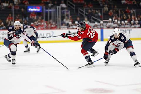 Sep 27, 2024; Washington, District of Columbia, USA; Washington Capitals forward Andrew Cristell (28) shoots the puck as Columbus Blue Jackets defenseman David Jiricek (55) and Blue Jackets center Dylan Gambrell (18) defend in the third period at Capital One Arena. Mandatory Credit: Geoff Burke-Imagn Images