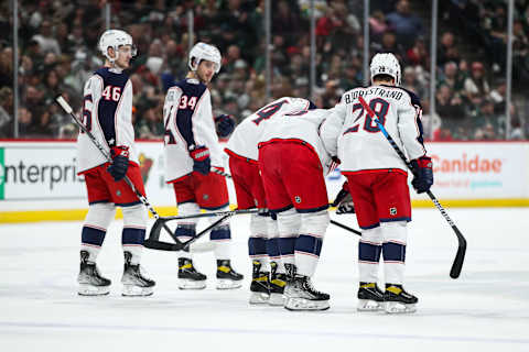 Mar 26, 2022; Saint Paul, Minnesota, USA; Columbus Blue Jackets defenseman Zach Werenski (8) is helped off the ice by teammates after suffering an apparent injury against the Minnesota Wild in the first period at Xcel Energy Center. Mandatory Credit: David Berding-Imagn Images