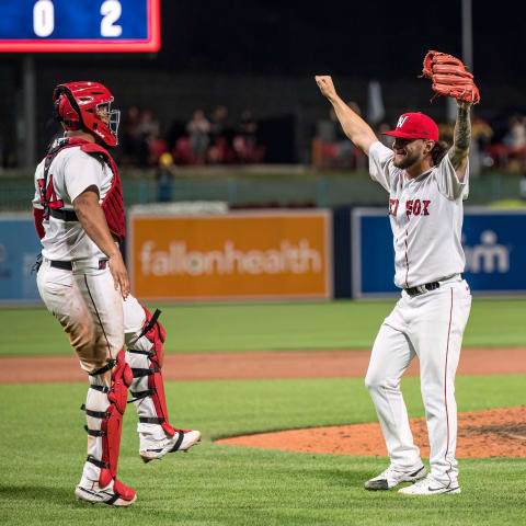 Worcester reliever Chase Shugart, right, and catcher Ronaldo Hern  ndez celebrate the end of a