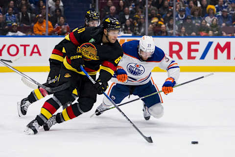 Edmonton Oilers forward Warren Foegele (37) battles Canuck Forward