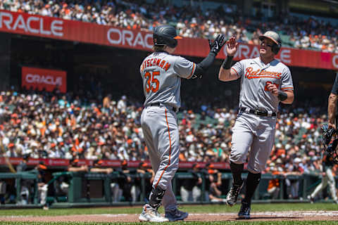 Jun 4, 2023; San Francisco, California, USA;  Baltimore Orioles catcher James McCann (27) is congratulated by designated hitter Adley Rutschman (35) after he scored against the San Francisco Giants during the third inning at Oracle Park. Mandatory Credit: John Hefti-Imagn Images