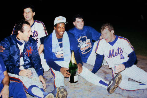 Mets Rick Aguilera, Lenny Dykstra, Bobby Ojeda, and Dwight Gooden celebrate on the field after