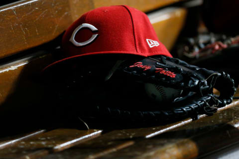 The hat and glove of Cincinnati Reds first baseman Joey Votto (19) wait in the dugout.