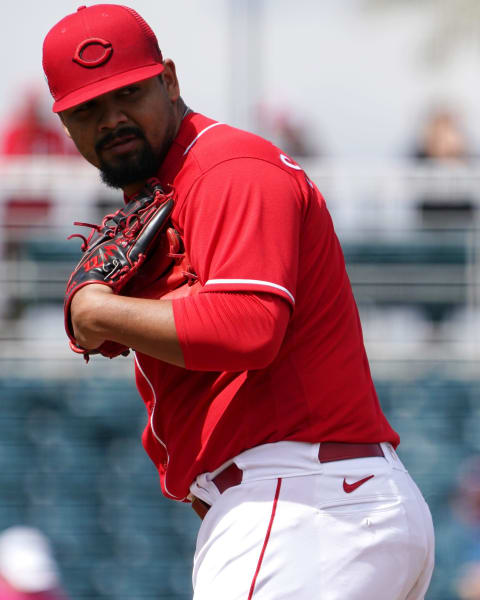 Cincinnati Reds pitcher Tony Santillan (64) checks the runner at first base during a spring training game.