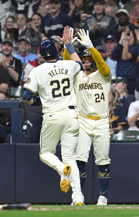 May 10, 2024; Milwaukee, Wisconsin, USA; Milwaukee Brewers outfielder Christian Yelich (22) is congratulated by Milwaukee Brewers catcher William Contreras (24) after scoring from second base in the fourth inning against the St. Louis Cardinals at American Family Field. Mandatory Credit: Michael McLoone-USA TODAY Sports