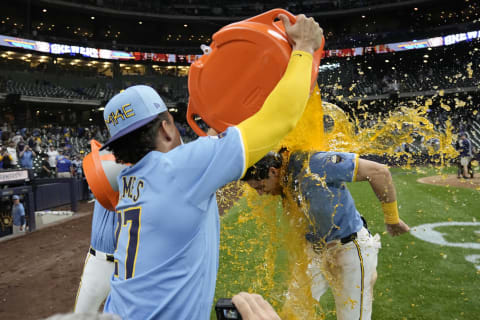 May 31, 2024; Milwaukee, Wisconsin, USA;  Milwaukee Brewers shortstop Willy Adames (27) dunks left fielder Christian Yelich (22) with Gatorade following the game against the Chicago White Sox at American Family Field. Mandatory Credit: Jeff Hanisch-USA TODAY Sports