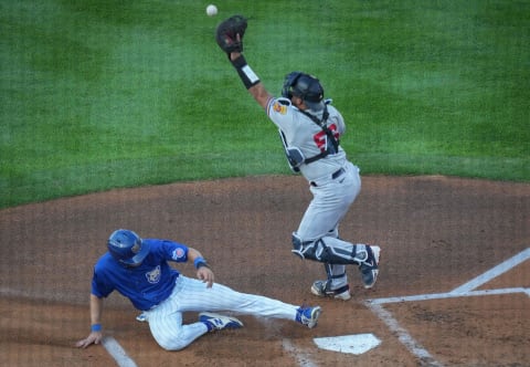 Iowa Cubs center fielder Darius Hill slides safely across home plate ahead of the tag by St. Paul