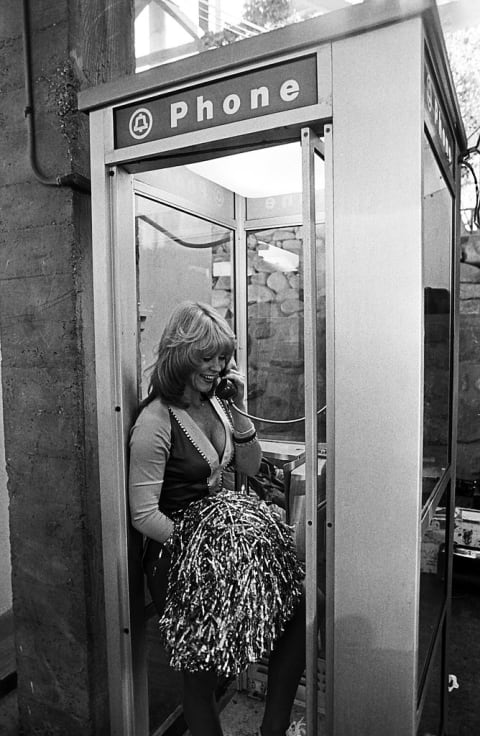 An L.A. Rams cheerleader makes a phone call at halftime.