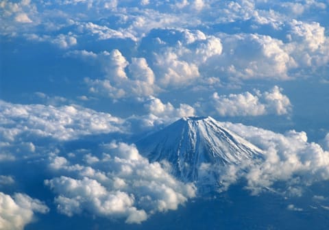 The peak of Mount Fuji peeking through the clouds.