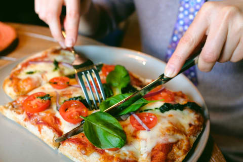 Depending on where you are, eating pizza with a knife and fork can be controversial.