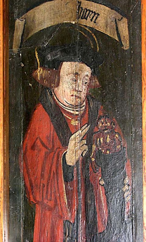 A medieval rood screen in St. Gregory's Church in Sudbury, Suffolk, UK, pictures John Schorn holding the devil in a boot.