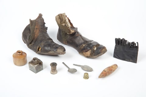 Women's leather boots (1860s) found in servants’ quarters in a Brackley, Northants. home, along with a leather purse, spoons, ink bottle, and more.