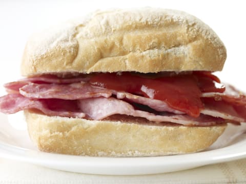 A bacon butty with ketchup.