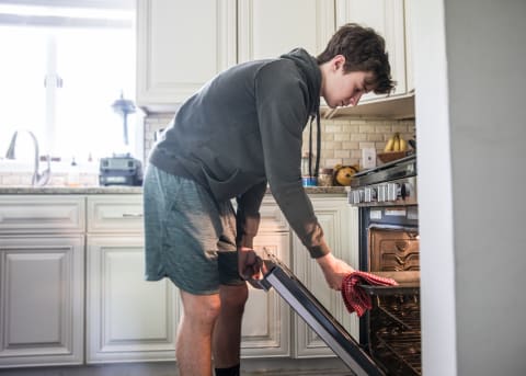 Taking anything out of the oven with a dish towel isn’t recommended.