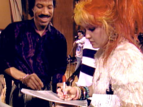 Lionel Richie and Cyndi Lauper work to record "We Are the World."