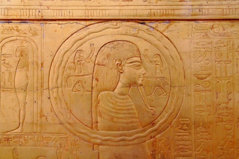 A relief sculpture from the tomb of Tutankhamun shows an ouroboros circling a man's head.