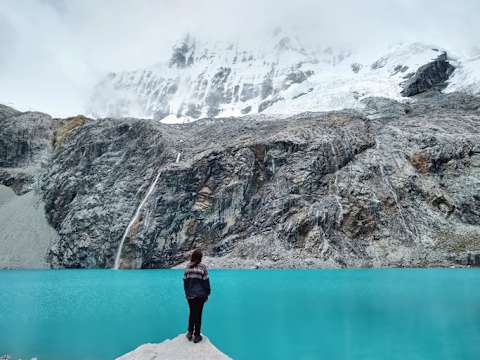 A woman admires a glacial lake in Huascarán National Park.