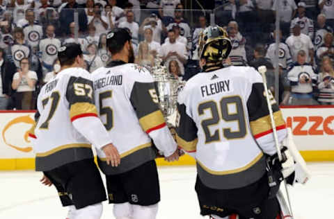 WINNIPEG, MB – MAY 20: Deryk Engelland #5, David Perron #57 and goaltender Marc-Andre Fleury #29 of the Vegas Golden Knights carry the Clarence S. Campbell Trophy off the ice following a 2-1 victory over the Winnipeg Jets in Game Five of the Western Conference Final during the 2018 NHL Stanley Cup Playoffs at the Bell MTS Place on May 20, 2018 in Winnipeg, Manitoba, Canada. The Knights win the series 4-1. (Photo by Jonathan Kozub/NHLI via Getty Images)