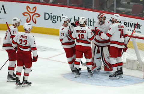 GLENDALE, ARIZONA – APRIL 18: Goaltender Antti Raanta #32 of the Carolina Hurricanes is congratulated by Tony DeAngelo #77, Vincent Trocheck #16, and Jaccob Slavin #74 after defeating the Arizona Coyotes in the NHL game at Gila River Arena on April 18, 2022, in Glendale, Arizona. The Hurricanes defeated the Coyotes 5-3. (Photo by Christian Petersen/Getty Images)