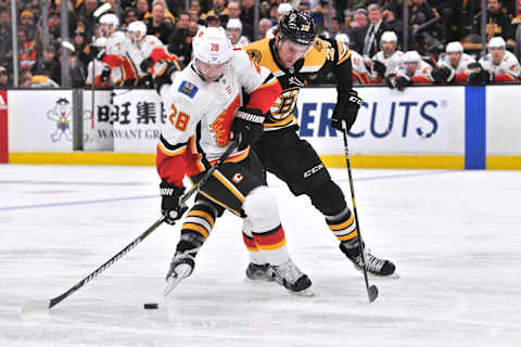 BOSTON, MA – JANUARY 03: Calgary Flames Right Wing Elias Lindholm (28) and Boston Bruins Defenceman Brandon Carlo (25) get tangled up battling for the puck. During the Calgary Flames game against the Boston Bruins on January 03, 2019 at TD Garden in Boston, MA. (Photo by Michael Tureski/Icon Sportswire via Getty Images)