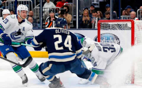 Oct 18, 2022; Columbus, Ohio, USA; Vancouver Canucks goalie Spencer Martin (30) makes a save on the shot from Columbus Blue Jackets center Mathieu Olivier (24) during the second period at Nationwide Arena. Mandatory Credit: Russell LaBounty-USA TODAY Sports