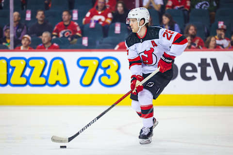 Mar 16, 2022; Calgary, Alberta, CAN; New Jersey Devils defenseman Damon Severson (28) controls the puck against the Calgary Flames during the first period at Scotiabank Saddledome. Mandatory Credit: Sergei Belski-USA TODAY Sports