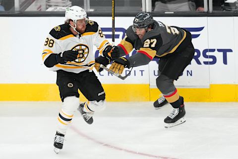 Mar. 3, 2022; Las Vegas, Nevada, USA; Boston Bruins right wing David Pastrnak (88) skates around the checking attempt of Vegas Golden Knights defenseman Shea Theodore (27) during the second period at T-Mobile Arena. Mandatory Credit: Stephen R. Sylvanie-USA TODAY Sports