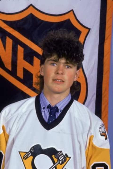 Czech professional hockey player Jaromir Jagr of the Pittsburgh Penguins poses in front of the National Hockey League logo wearing a shirt and tie underneath his jersey at the 1990 NHL draft, 1990. (Photo by Brian Miller/Getty Images)