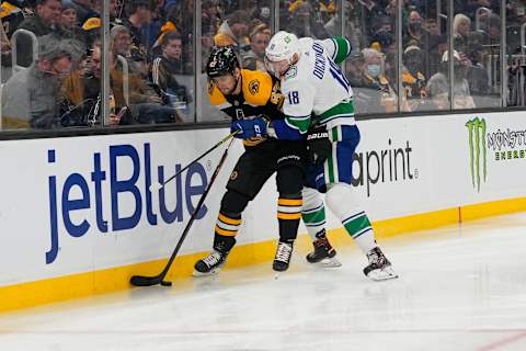 Nov 28, 2021; Boston, Massachusetts, USA; Vancouver Canucks center Jason Dickinson (18) checks Boston Bruins defenseman Jakub Zboril (67) with the puck during the second period at TD Garden. Mandatory Credit: Gregory Fisher-USA TODAY Sports