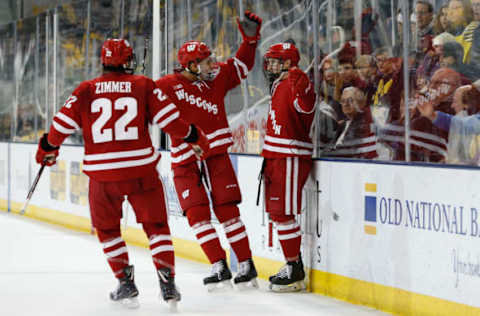 ANN ARBOR, MI – NOVEMBER 24: Wisconsin Badgers forward Max Zimmer (22), left, and Wisconsin Badgers defenseman K’Andre Miller (19), center, celebrate a score with a teammate during a regular season Big 10 Conference hockey game between the Wisconsin Badgers and Michigan Wolverines on November 24, 2018 at Yost Ice Arena in Ann Arbor, Michigan. (Photo by Scott W. Grau/Icon Sportswire via Getty Images)