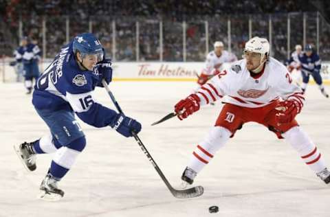 Jan 1, 2017; Toronto, Ontario, CAN; Toronto Maple Leafs center Mitch Marner (16) shoots as Detroit Red Wings defenseman Brendan Smith (2) defends during the Centennial Classic ice hockey game at BMO Field. The Maple Leafs beat the Red Wings 5-4 in overtime. Mandatory Credit: Tom Szczerbowski-USA TODAY Sports