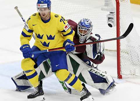 Sweden’s forward Rasmus Asplund vies with Latvia’s goalkeeper Arturs Silovs (R) during the IIHF Ice Hockey World Championships preliminary round group B match between Sweden and Latvia at the Nokia Arena in Tampere, Finland, on May 24, 2022. – Finland OUT (Photo by Jussi Nukari / Lehtikuva / AFP) / Finland OUT (Photo by JUSSI NUKARI/Lehtikuva/AFP via Getty Images)