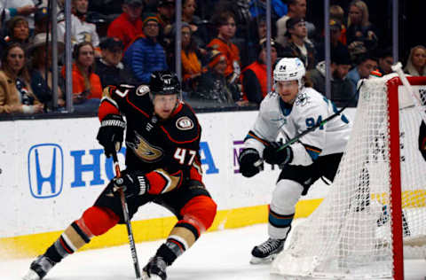 ANAHEIM, CALIFORNIA – FEBRUARY 22: Hampus Lindholm #47 of the Anaheim Ducks skates the puck against Alexander Barabanov #94 of the San Jose Sharks in the second period at Honda Center on February 22, 2022 in Anaheim, California. (Photo by Ronald Martinez/Getty Images)