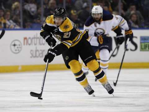 Feb 4, 2016; Buffalo, NY, USA; Boston Bruins left wing Loui Eriksson (21) heads up ice with the puck as Buffalo Sabres defenseman Zach Bogosian (47) pursues during the first period at First Niagara Center. Mandatory Credit: Kevin Hoffman-USA TODAY Sports