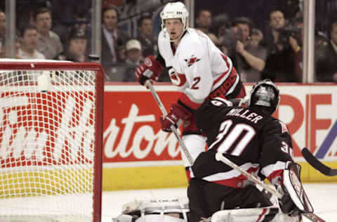 Ryan Miller #30 of the Buffalo Sabres makes a glove save while Hurricanes’ Eric Staal #12 waits for the rebound during game 6 of the Eastern Conference Finals versus the Carolina Hurricanes at the HSBC Arena in Buffalo, New York, May 30, 2006. (Photo by Jerome Davis/NHLImages)