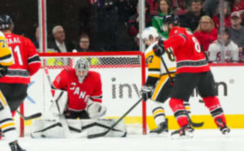 Dec 18, 2022; Raleigh, North Carolina, USA; Carolina Hurricanes goaltender Pyotr Kochetkov (52) defenseman Brent Burns (8) and Pittsburgh Penguins center Sidney Crosby (87) watch the shot during the first period at PNC Arena. Mandatory Credit: James Guillory-USA TODAY Sports